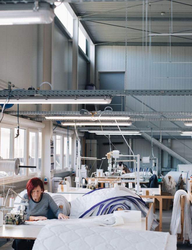 PH-factory-hall-woman-sew@2x Intelligente Gebäudeautomation von MilliSense in einem Betrieb.